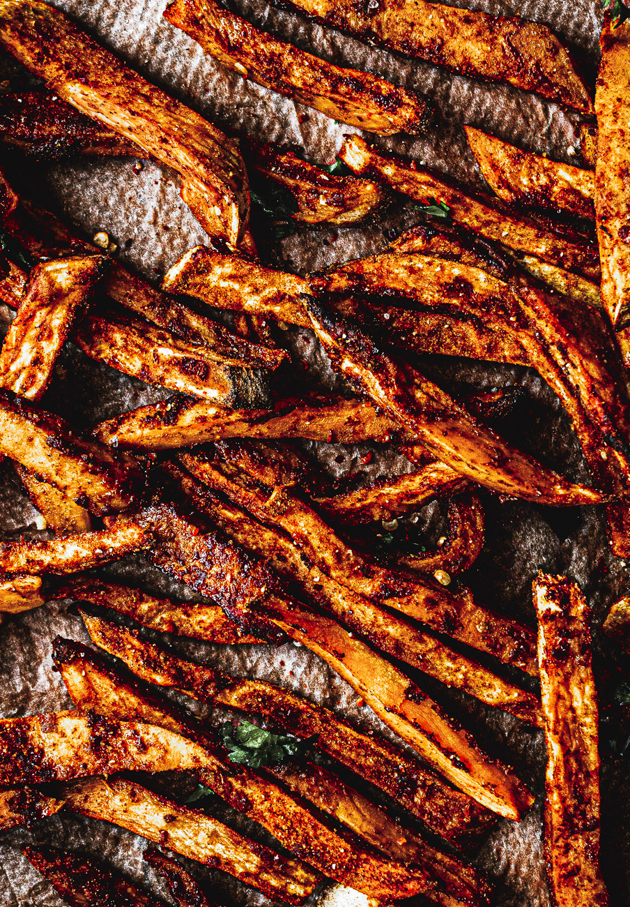 a flay lay of scattered sweet potato fries with a tomato ketchup dip  close up 