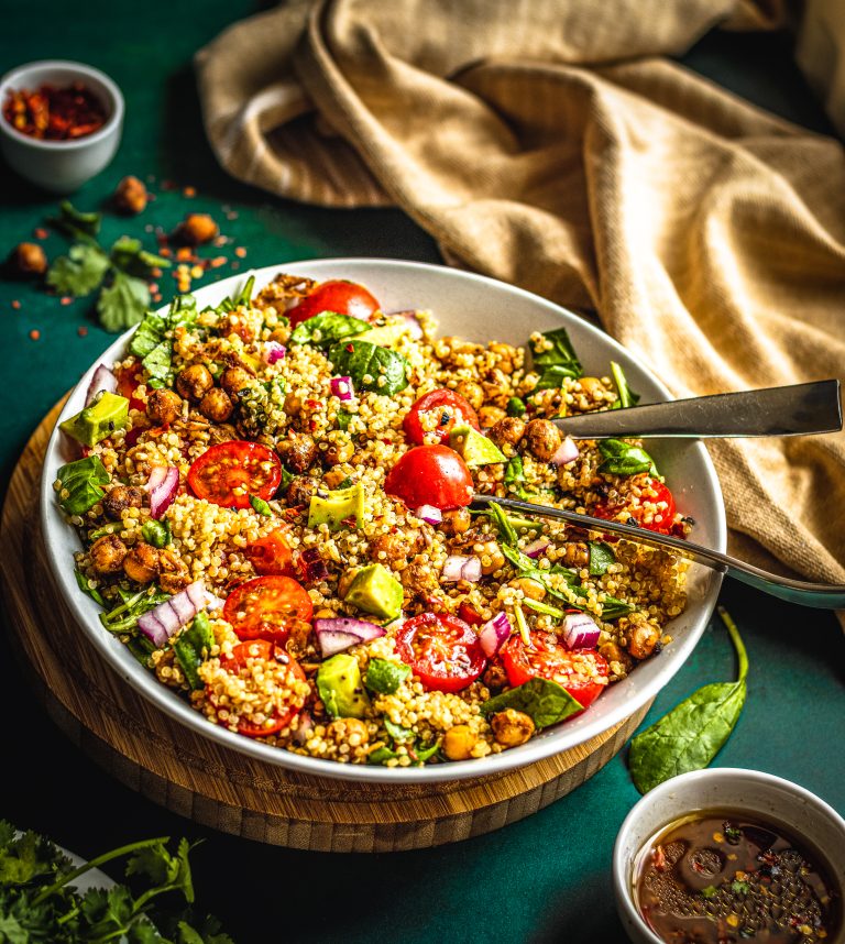 Quinoa chickpea salad with avocado, cherry tomatoes, spinach, and lemon vinaigrette in a bowl – fresh and healthy meal prep recipe