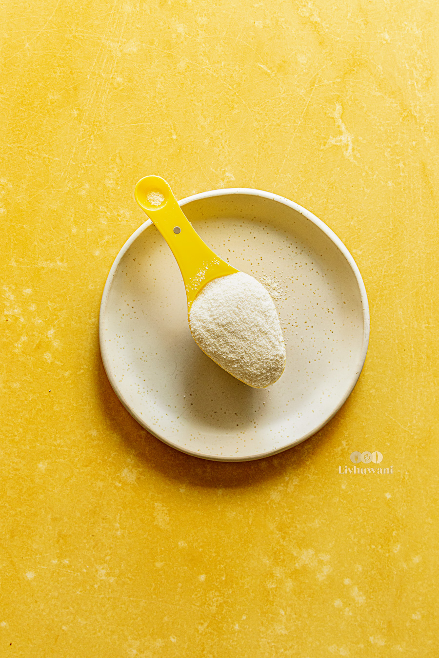 Maize Meal, mugayo, mielie meal, in a yellow scoop.